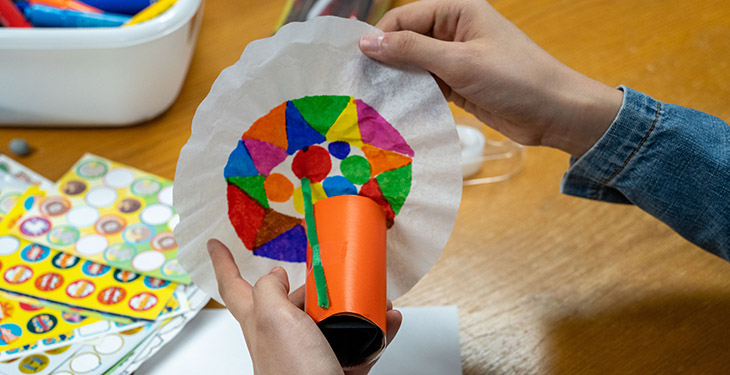 Tape the pipe cleaner to the side of the cardboard tube