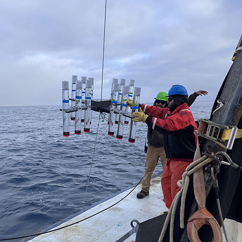 Scientists and crew deploy a sediment trap and the accompanying floats aboard the Research Vessel Roger Revelle picture 1