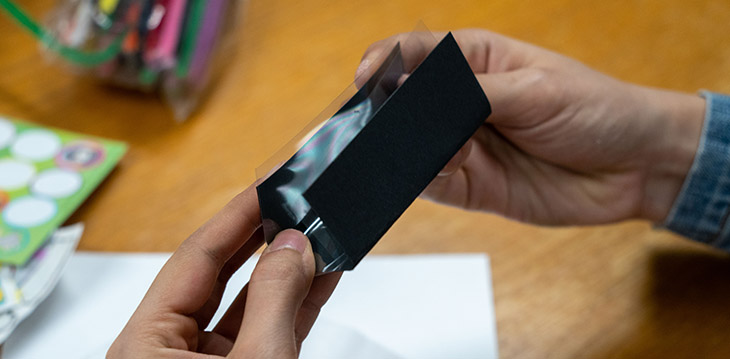 Form the transparent paper and the black cardstock to a triangular shaped tube